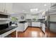 Open kitchen with stainless appliances, white cabinetry, black counters, and access to a screened outdoor space at 103 Cherry Hill Cir, Longwood, FL 32779