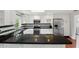 Bright kitchen offers white cabinetry, stainless steel appliances, black granite countertops, and a breakfast bar at 103 Cherry Hill Cir, Longwood, FL 32779