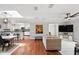 Open-concept living area with hardwood floors, brick accent wall, and skylight enhances spaciousness at 103 Cherry Hill Cir, Longwood, FL 32779