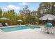 Inviting pool area with a striped umbrellas, lounge chairs, and lush landscaping at 103 Cherry Hill Cir, Longwood, FL 32779