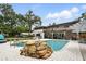 Inviting backyard pool with a unique rock feature and outdoor dining area at 103 Cherry Hill Cir, Longwood, FL 32779