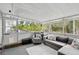 Cozy screened porch featuring a comfortable sectional sofa, plush armchair, and a neutral color palette at 103 Cherry Hill Cir, Longwood, FL 32779