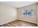 This bedroom has wood-look floors and a window offering natural light and neighborhood views at 108 N Truett St, Leesburg, FL 34748