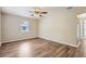 Spacious bedroom with a ceiling fan, wood floors, and natural light from a window at 108 N Truett St, Leesburg, FL 34748