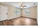 Cozy bedroom with wood floors, a ceiling fan, and two windows offering natural light at 108 N Truett St, Leesburg, FL 34748