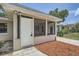 Exterior shot highlighting a cozy screened porch and mulch landscaping at 108 N Truett St, Leesburg, FL 34748