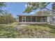 The back of the home features a sunroom to enjoy outdoor living on a budget at 108 N Truett St, Leesburg, FL 34748