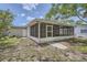 The rear of the home has a spacious sunroom for enjoying the outdoors, rain or shine at 108 N Truett St, Leesburg, FL 34748