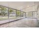 Enclosed sunroom with many windows and a concrete floor for versatile use and relaxation at 108 N Truett St, Leesburg, FL 34748