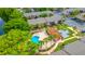 Aerial of lakefront complex showcasing the community pool, lounge areas, and mature landscaping at 1177 Paseo Del Mar # D, Casselberry, FL 32707