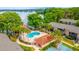 Aerial shot of the community pool with lounge seating, clubhouse, and lake view at 1177 Paseo Del Mar # D, Casselberry, FL 32707