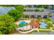 Community pool and clubhouse area are surrounded by lush palms and verdant lawn at 1177 Paseo Del Mar # D, Casselberry, FL 32707
