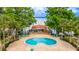 Aerial view of a community pool with lounge chairs and a covered patio overlooking the lake at 1177 Paseo Del Mar # D, Casselberry, FL 32707