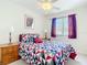 Bright bedroom featuring a geometric patterned bedspread, bedside tables with lamps, and a window with curtains at 1201 S Beach Cir, Kissimmee, FL 34746