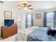 Bedroom with a ceiling fan, a dresser, and a bed with a blue and white patterned comforter at 1201 S Beach Cir, Kissimmee, FL 34746