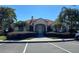 Well-maintained clubhouse with tile roof, arched entrance, and meticulously landscaped grounds at 1201 S Beach Cir, Kissimmee, FL 34746