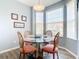 Charming dining area features a glass table, wood chairs, and natural light from large windows at 1201 S Beach Cir, Kissimmee, FL 34746