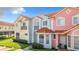 Colorful townhouses featuring tile roofs, manicured lawns, and decorative architectural details at 1201 S Beach Cir, Kissimmee, FL 34746