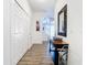 Bright hallway featuring wood floors, white walls, storage closet, and decorative mirror at 1201 S Beach Cir, Kissimmee, FL 34746