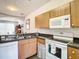 Functional kitchen featuring wooden cabinetry, granite countertops, and modern appliances at 1201 S Beach Cir, Kissimmee, FL 34746