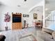 Spacious living room featuring hardwood floors, wooden TV cabinet and access to kitchen and stairs at 1201 S Beach Cir, Kissimmee, FL 34746