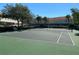 Tennis court surrounded by trees and multi story buildings at 1201 S Beach Cir, Kissimmee, FL 34746