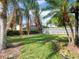 Manicured lawn with tropical landscaping and a white picket fence at 1319 Castleport Rd, Winter Garden, FL 34787