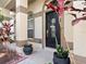 Close-up of a home's front door with decorative accents, plants and a 'Welcome Home' sign at 1319 Castleport Rd, Winter Garden, FL 34787