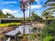 Landscaped backyard showcasing a serene rock water feature with lush greenery at 1319 Castleport Rd, Winter Garden, FL 34787