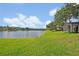 Lush backyard with green grass and lake view, perfect for outdoor activities and relaxation at 14545 Braddock Oak Dr, Orlando, FL 32837