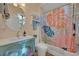 Bathroom with a modern vanity, large mirror, and a shower with a colorful tropical-themed curtain at 14545 Braddock Oak Dr, Orlando, FL 32837