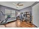 Bedroom featuring a window with blinds, dark wood flooring, a ceiling fan, and exercise equipment at 14545 Braddock Oak Dr, Orlando, FL 32837