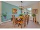 Bright dining room featuring a wooden table with seating for six, complemented by a modern chandelier and a large window at 14545 Braddock Oak Dr, Orlando, FL 32837