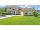 Inviting exterior view of a tan two-story home featuring a manicured lawn and a spacious three-car garage at 14545 Braddock Oak Dr, Orlando, FL 32837