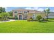 Charming two-story home with a well-manicured lawn, lush landscaping, and a beautiful paver driveway at 14545 Braddock Oak Dr, Orlando, FL 32837