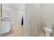 Well-lit bathroom with a granite vanity, tile flooring, toilet, and walk-in shower with a blue shower curtain at 1511 Barberry Dr, Kissimmee, FL 34744