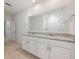 Modern bathroom with double vanity, granite countertop, and a large mirror at 1511 Barberry Dr, Kissimmee, FL 34744