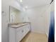 Bright bathroom featuring double sinks, a granite countertop, and a glass-enclosed shower at 1511 Barberry Dr, Kissimmee, FL 34744