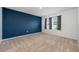 A carpeted bedroom features a contrasting accent wall, and a bright window with neighborhood views at 1511 Barberry Dr, Kissimmee, FL 34744