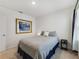 Bright bedroom featuring a cozy bed with gray comforter, and a framed painting on a white wall at 1511 Barberry Dr, Kissimmee, FL 34744
