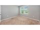 Bright bedroom with a neutral color scheme, plush carpet, and a window offering natural light and serene views at 1511 Barberry Dr, Kissimmee, FL 34744