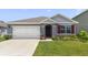 Charming single-Gathering home showcasing a well-manicured lawn, two car garage, and inviting front entrance at 1511 Barberry Dr, Kissimmee, FL 34744