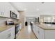 Well-lit kitchen featuring a breakfast bar, granite countertops and stainless steel appliances at 1511 Barberry Dr, Kissimmee, FL 34744