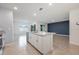 A kitchen island with a sink is the center of the living area, and is finished with white cabinets and granite countertops at 1511 Barberry Dr, Kissimmee, FL 34744