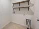 Functional laundry room with open shelving and tile flooring, ready for appliances at 1511 Barberry Dr, Kissimmee, FL 34744