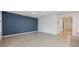 Open-concept living room featuring tile flooring, a blue accent wall, ample natural light, and seamless flow at 1511 Barberry Dr, Kissimmee, FL 34744