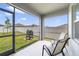 Screened-in patio with chairs and a grill overlooking a fenced backyard and lush green grass at 1511 Barberry Dr, Kissimmee, FL 34744