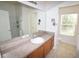 Bathroom vanity with storage and a large mirror, tiled floor and natural light at 15349 Oak Apple Ct # B, Winter Garden, FL 34787
