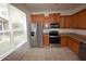 Bright kitchen with stainless steel appliances, wooden cabinets, and tile flooring by a large window at 15349 Oak Apple Ct # B, Winter Garden, FL 34787