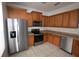 Modern kitchen featuring stainless steel appliances, ample wood cabinetry, and tile flooring at 15349 Oak Apple Ct, Winter Garden, FL 34787